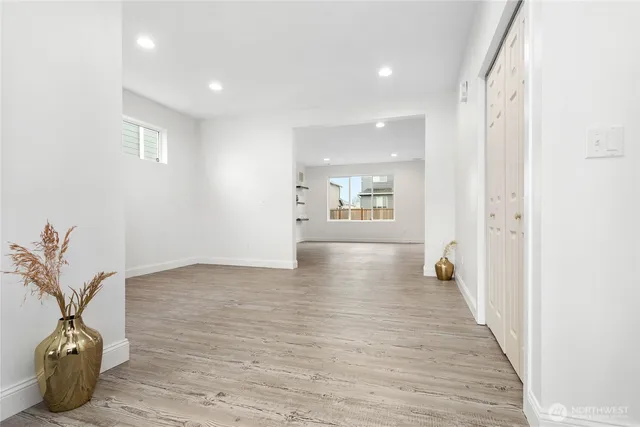 a view of a hallway with wooden floor and a potted plant