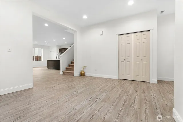 a view of empty room with wooden floor and windows