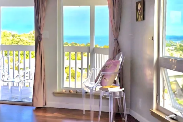 a view of an empty room with wooden floor and windows