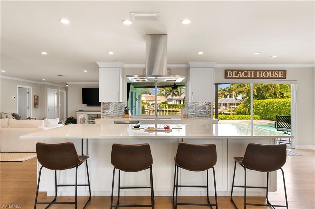 2140 Shad Court Naples, FL 34102 - Photo 30 of 44 a kitchen with stainless steel appliances a dining table chairs and a sink