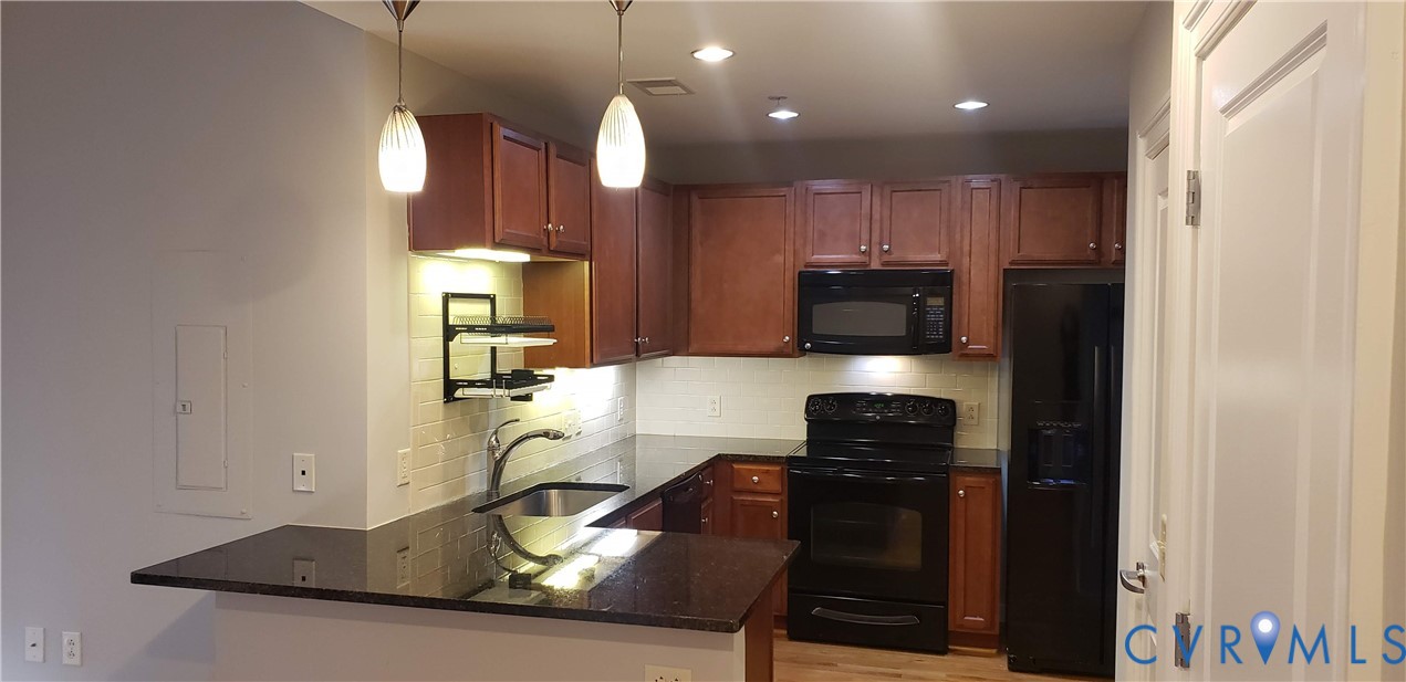 230 North 6th Street, Unit U613 Richmond, VA 23219 - Photo 2 of 10 a kitchen with granite countertop a stove and a refrigerator