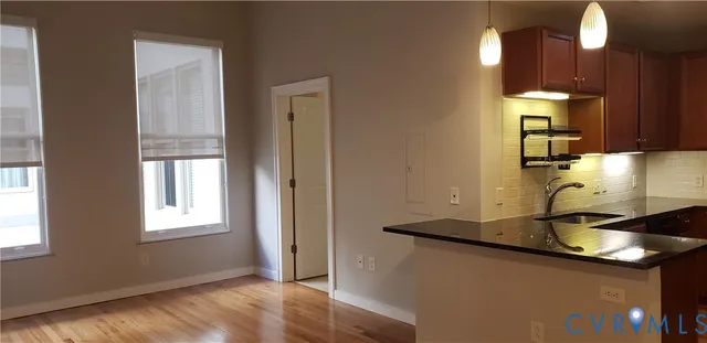 a kitchen with kitchen island granite countertop wooden cabinets and a sink
