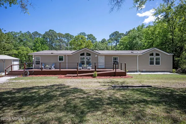 a view of a house with backyard and sitting area