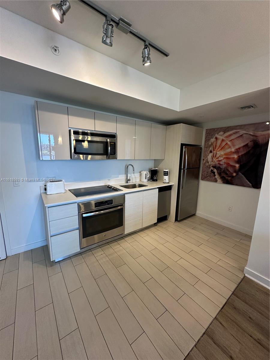 2602 East Hallandale Beach Boulevard, Unit R807 Hallandale Beach, FL 33009 - Photo 14 of 37 a kitchen with stainless steel appliances granite countertop a stove a sink and a refrigerator
