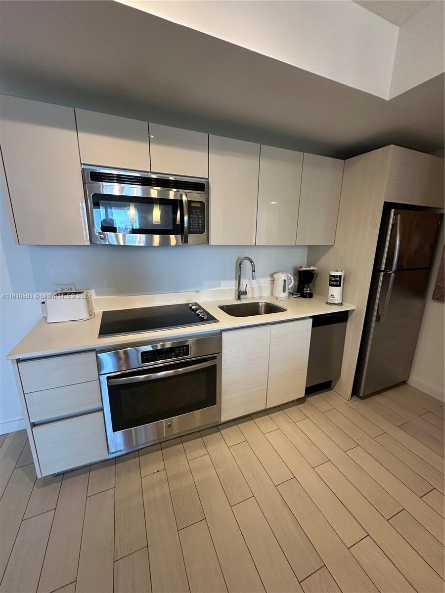 2602 East Hallandale Beach Boulevard, Unit R807 Hallandale Beach, FL 33009 - Photo 25 of 37 a kitchen with stainless steel appliances a sink a stove a microwave and cabinets