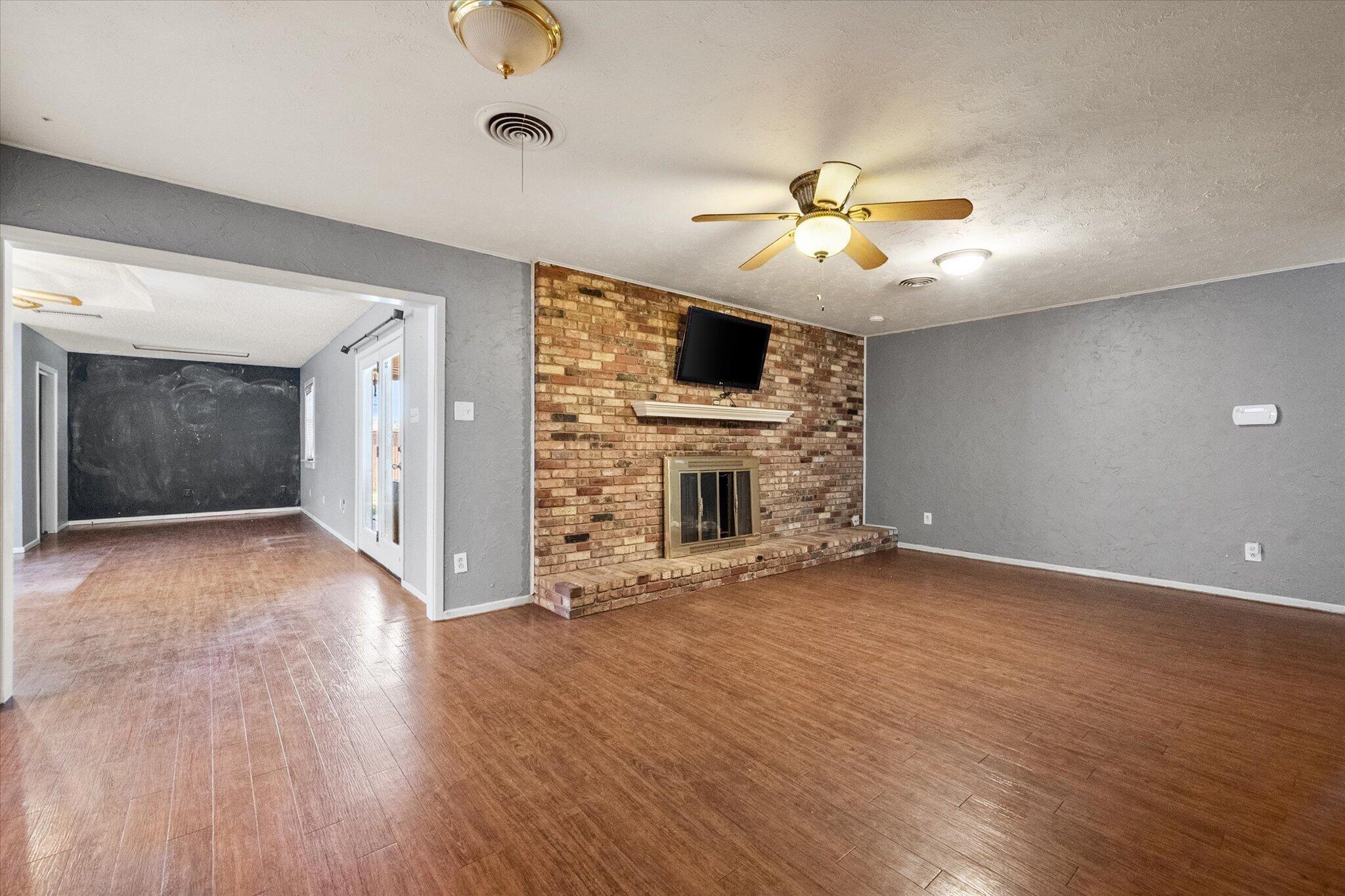 4604 27th Street Lubbock, TX 79410 - Photo 21 of 36 a view of a livingroom with a fireplace a ceiling fan and windows