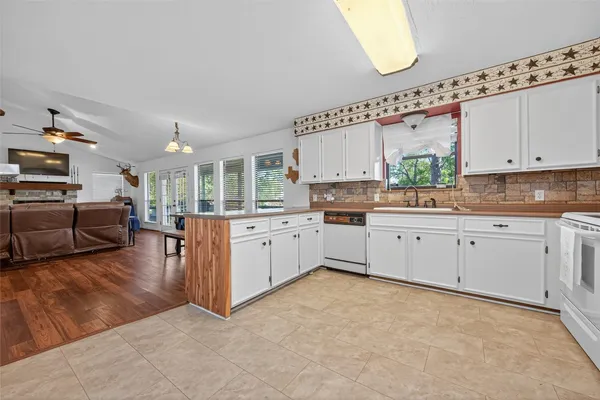a large white kitchen with a large window