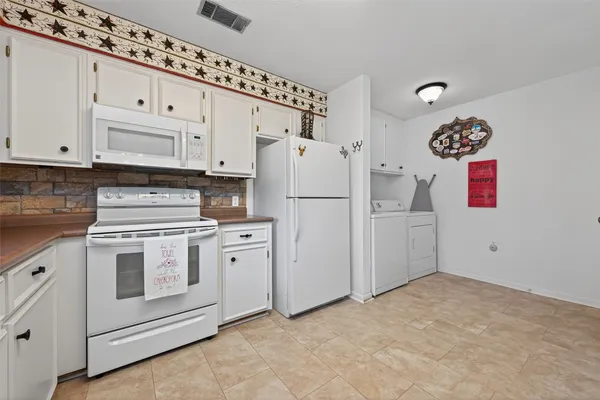 a kitchen with cabinets and white appliances