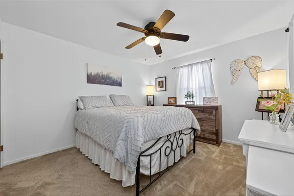 a spacious bedroom with a bed and a chandelier