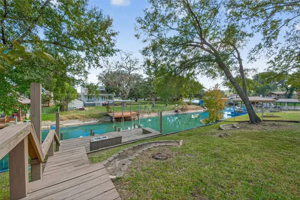 a view of a deck with a big yard and large trees