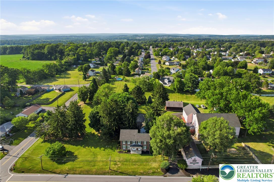 4682 Steuben Road Bethlehem, PA 18020 - Photo 3 of 79 An aerial panorama reveals a residential community nestled among lush green fields and mature trees.