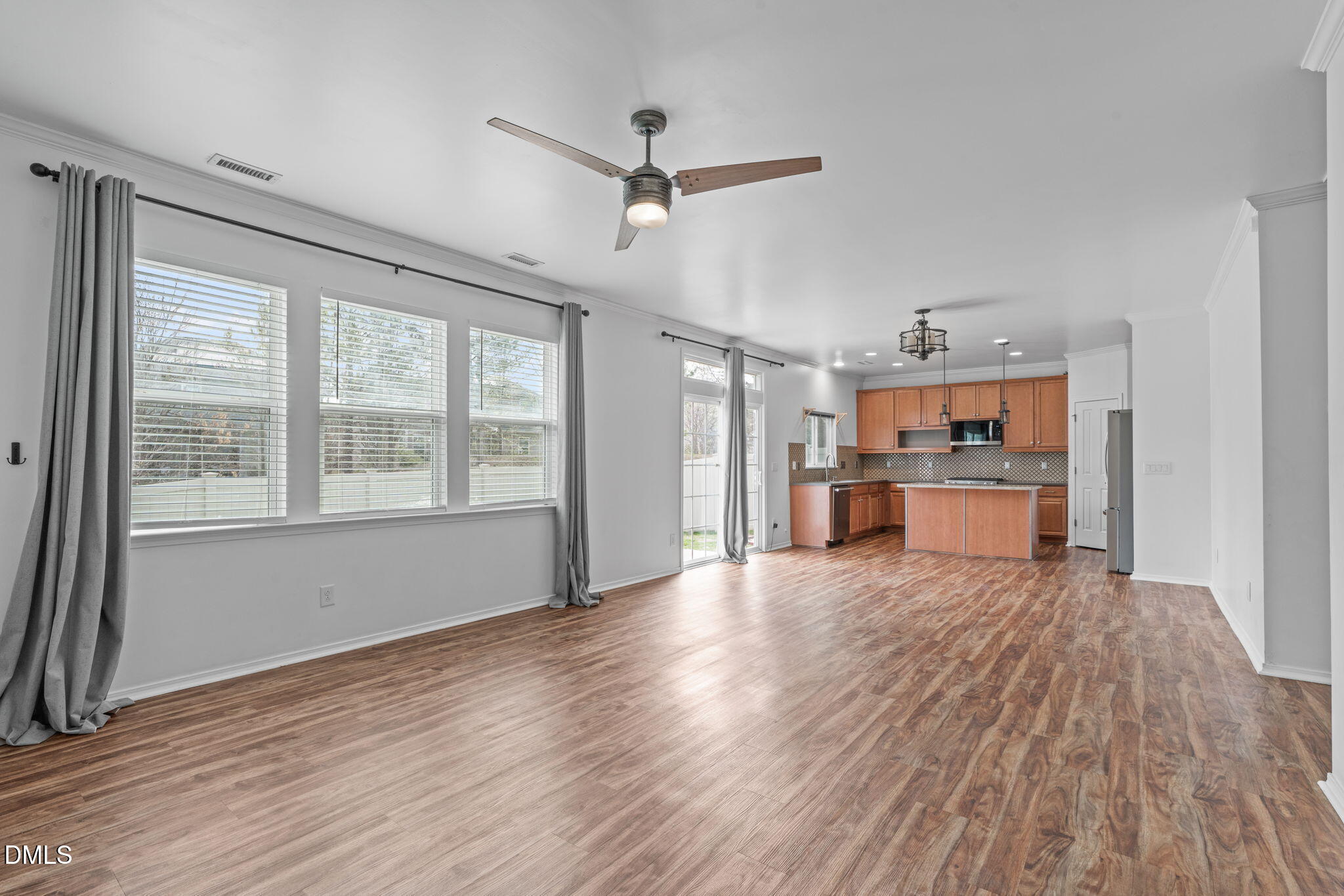 124 Daneborg Road Durham, NC 27703 - Photo 25 of 40 a big room with wooden floor a ceiling fan and windows