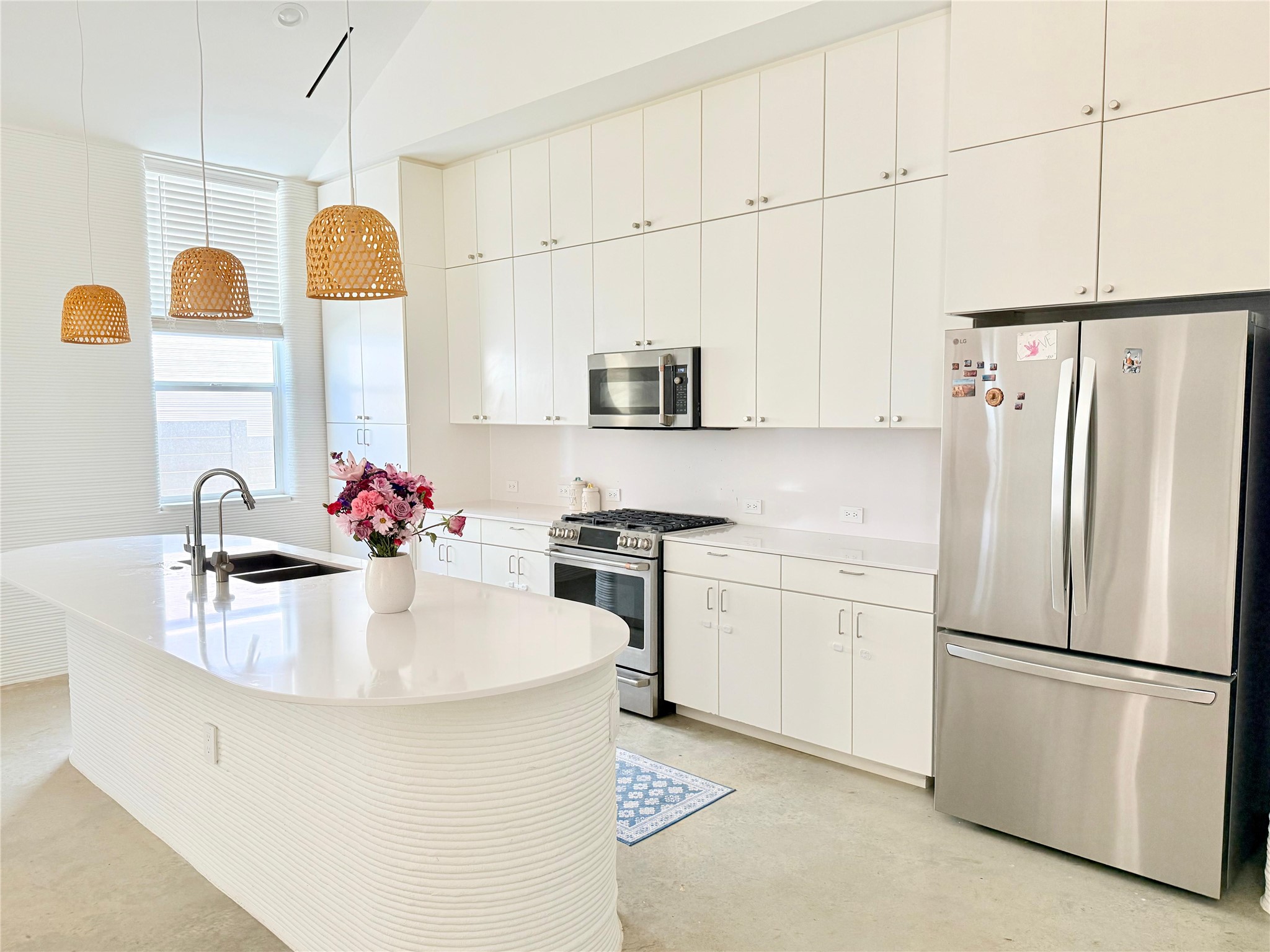 332 Blue Blaze Trail Georgetown, TX 78628 - Photo 4 of 16 Kitchen featuring stainless steel appliances, white cabinetry, hanging light fixtures, finished concrete flooring, and a center island with sink