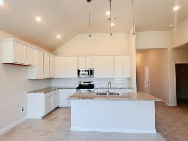 a kitchen with kitchen island cabinets and white appliances