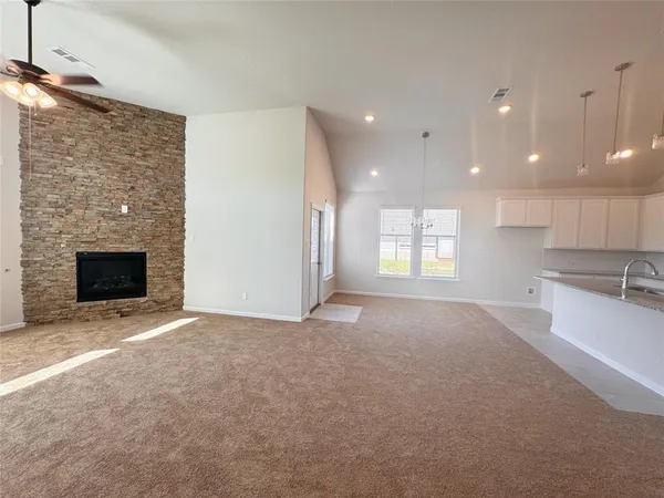 a view of an empty room with a fireplace and a window