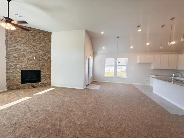 a view of an empty room with a fireplace and a window