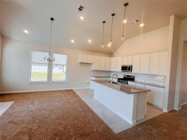 a kitchen with kitchen island a sink stainless steel appliances and window