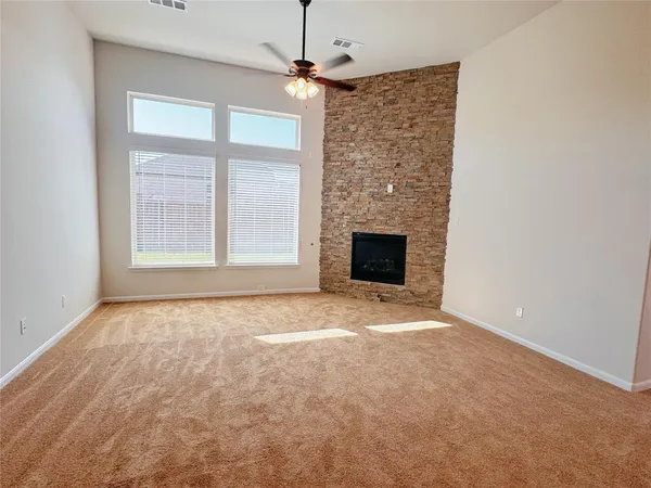 an empty room with windows and fireplace