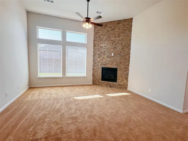 an empty room with windows and fireplace