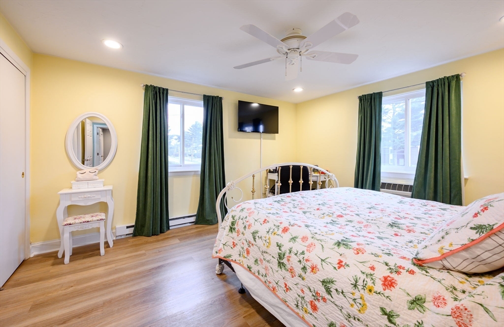 53 Will Drive, Unit 143 Canton, MA 02021 - Photo 13 of 23 a bedroom with a bed a mirror on dresser and a large window