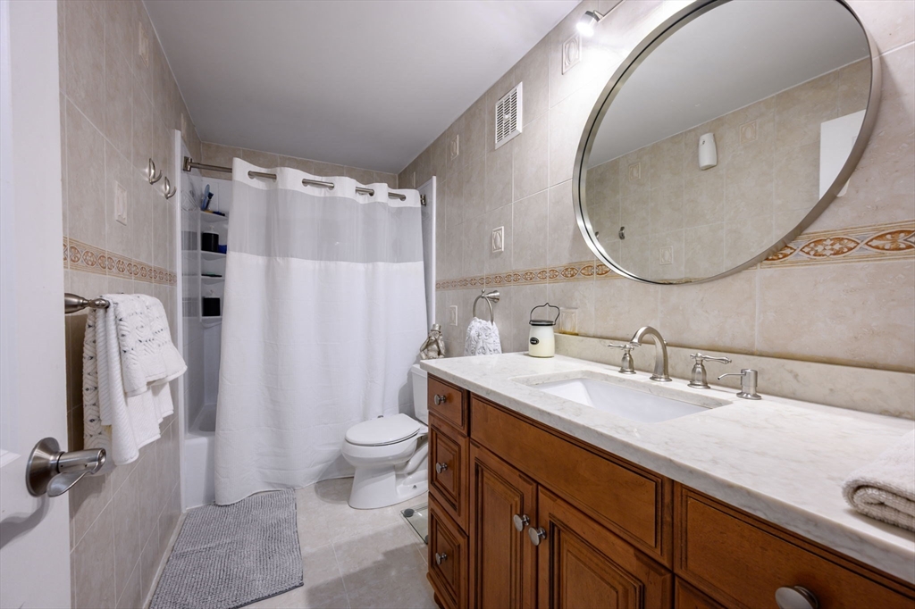 53 Will Drive, Unit 143 Canton, MA 02021 - Photo 16 of 23 a bathroom with a sink and a mirror