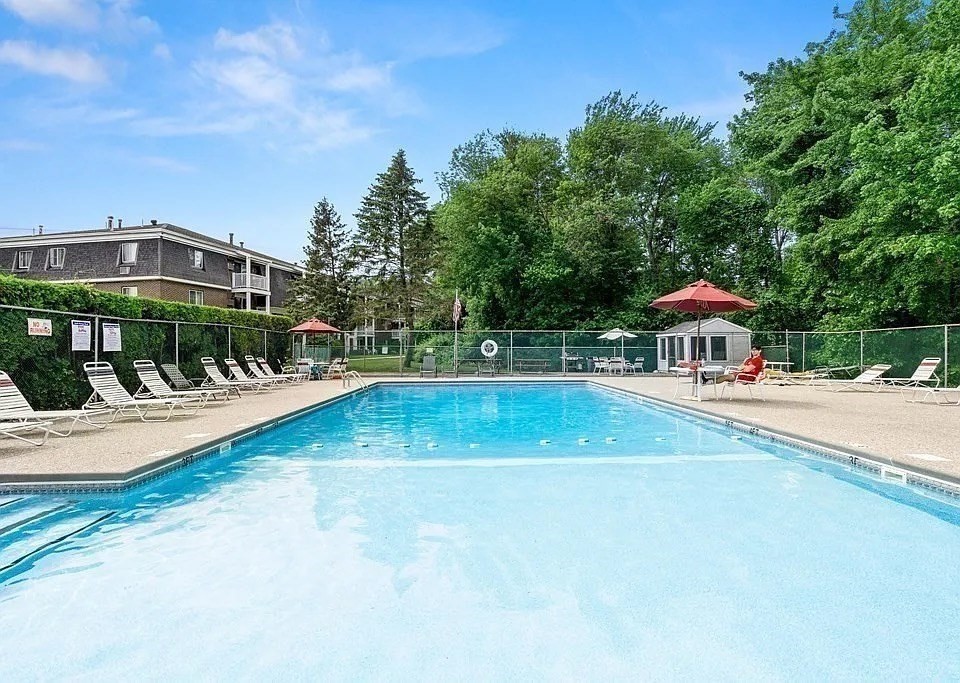 53 Will Drive, Unit 143 Canton, MA 02021 - Photo 18 of 23 a view of a swimming pool with a bench and trees