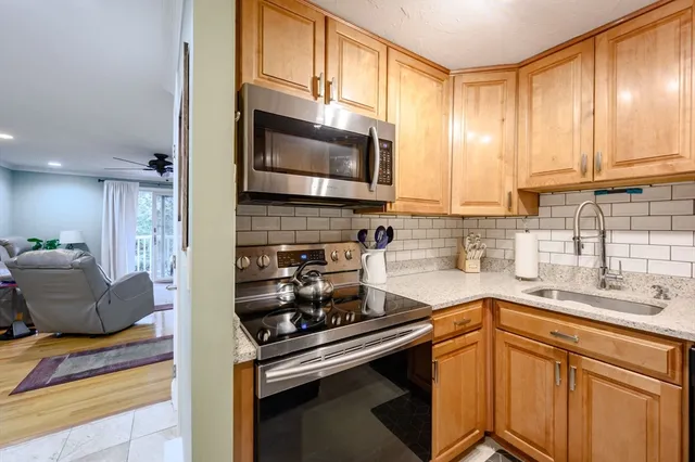 a kitchen with stainless steel appliances granite countertop a sink stove and cabinets