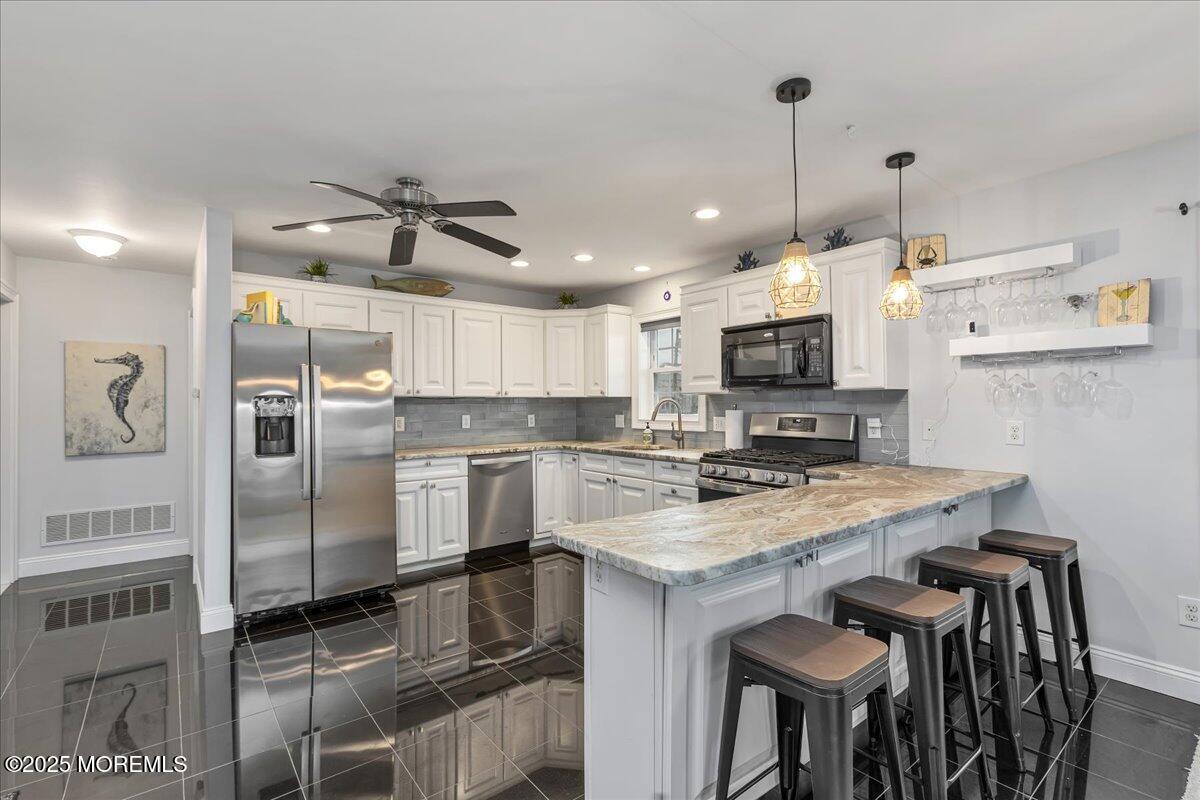 186 Flamingo Road Tuckerton, NJ 08087 - Photo 17 of 55 a kitchen with a refrigerator a stove a sink and chairs