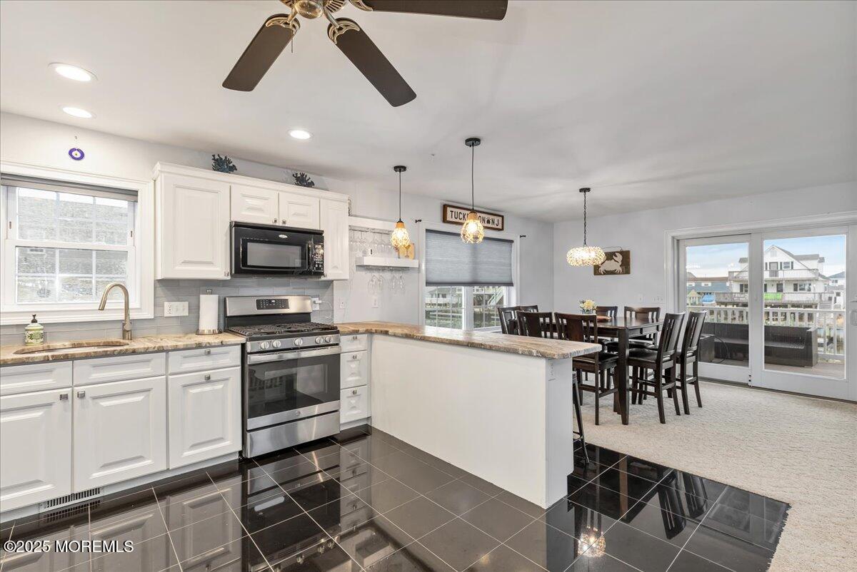 186 Flamingo Road Tuckerton, NJ 08087 - Photo 18 of 55 a kitchen with stainless steel appliances granite countertop a stove top oven a sink a dining table and chairs with wooden floor