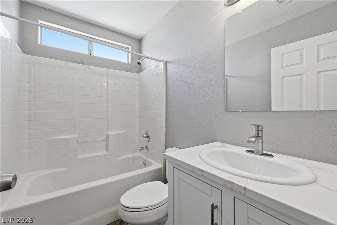 2780 West Simkins Road Pahrump, NV 89060 - Photo 30 of 40 A well-appointed bathroom features a combined tub and shower, alongside a modern vanity and window.