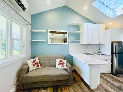 a living room with a couch and a stove next to a window