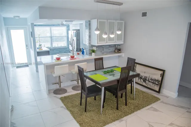 a kitchen with a dining table chairs and window