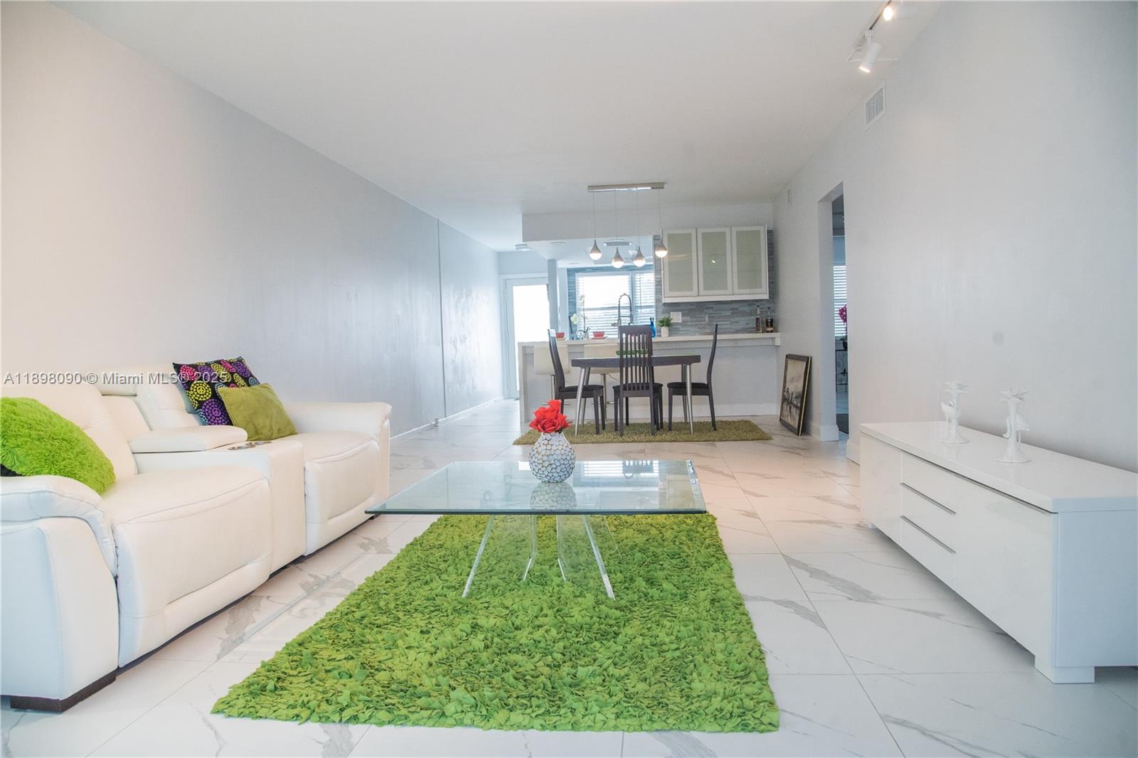 2304 Lucaya Lane, Unit J4 Coconut Creek, FL 33066 - Photo 24 of 50 a living room with furniture and a dining table with kitchen view