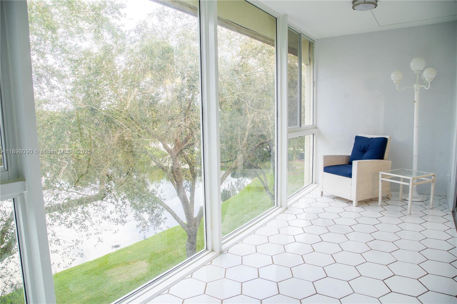 2304 Lucaya Lane, Unit J4 Coconut Creek, FL 33066 - Photo 29 of 50 a living room with a large window and a table