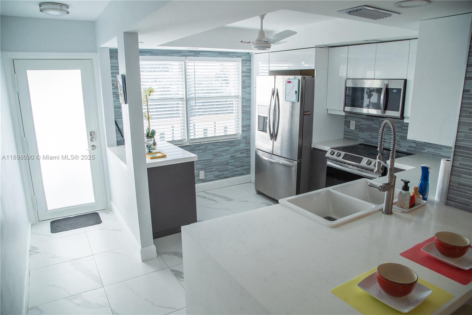 2304 Lucaya Lane, Unit J4 Coconut Creek, FL 33066 - Photo 3 of 50 a kitchen with stainless steel appliances granite countertop a refrigerator and a sink