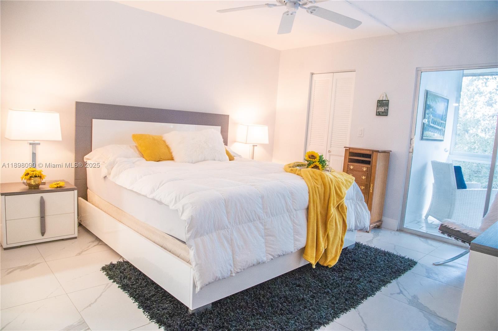 2304 Lucaya Lane, Unit J4 Coconut Creek, FL 33066 - Photo 34 of 50 a bedroom with a bed and a lamp on dresser