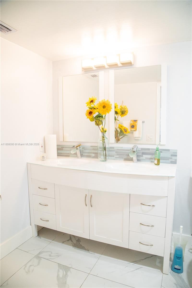 2304 Lucaya Lane, Unit J4 Coconut Creek, FL 33066 - Photo 42 of 50 a bathroom with a sink vanity and a mirror