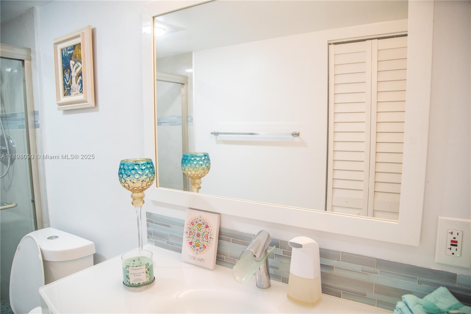 2304 Lucaya Lane, Unit J4 Coconut Creek, FL 33066 - Photo 49 of 50 a bathroom with a sink a toilet and a mirror