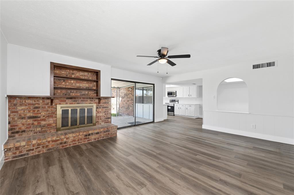 2119 Meadfoot Road Carrollton, TX 75007 - Photo 11 of 34 Unfurnished living room with a fireplace, dark wood-type flooring, and ceiling fan