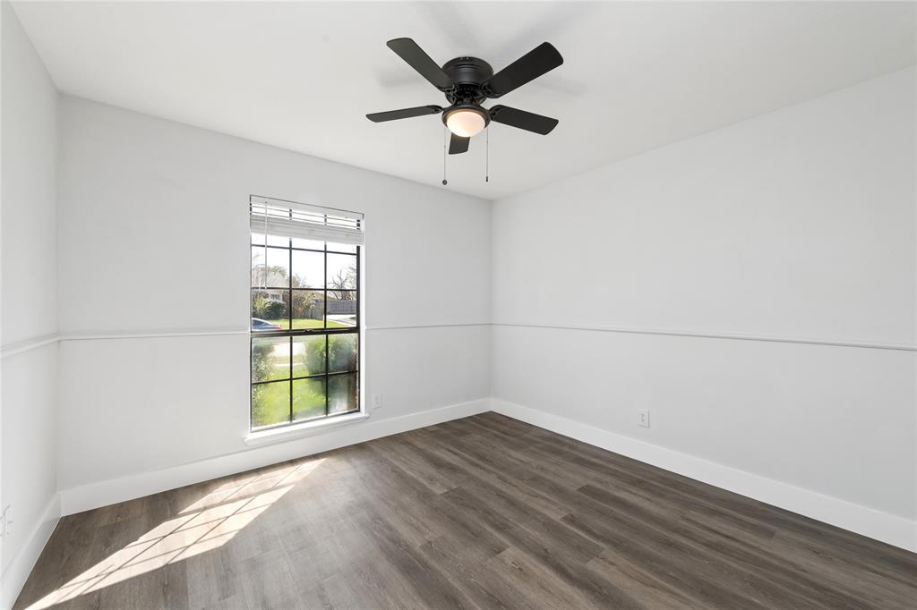 2119 Meadfoot Road Carrollton, TX 75007 - Photo 12 of 34 Spare room featuring a ceiling fan and dark wood-style floors