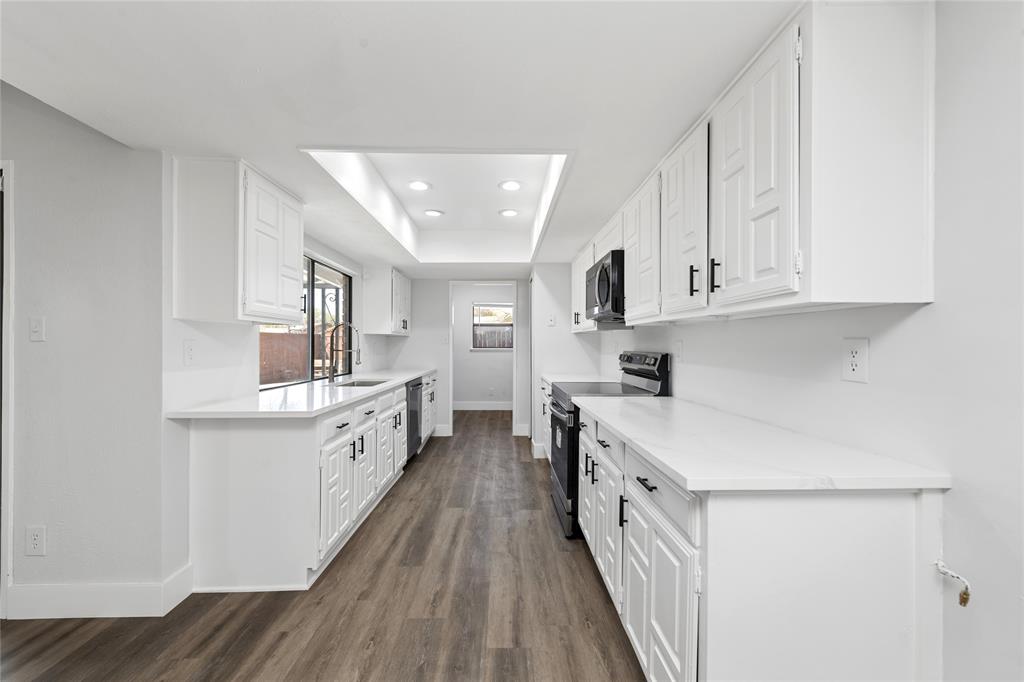 2119 Meadfoot Road Carrollton, TX 75007 - Photo 14 of 34 Kitchen featuring stainless steel appliances, recessed lighting, white cabinetry, dark wood-type flooring, and a raised ceiling