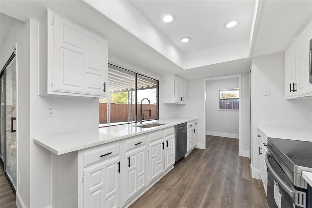 2119 Meadfoot Road Carrollton, TX 75007 - Photo 15 of 34 Kitchen with white cabinetry, stainless steel appliances, recessed lighting, dark wood-style flooring, and light stone countertops