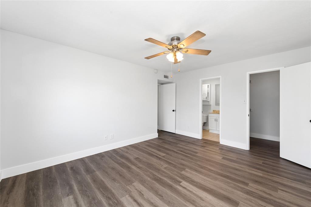 2119 Meadfoot Road Carrollton, TX 75007 - Photo 18 of 34 Unfurnished bedroom featuring a ceiling fan, dark wood-type flooring, a spacious closet, and ensuite bath