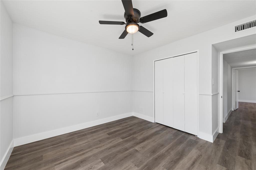 2119 Meadfoot Road Carrollton, TX 75007 - Photo 20 of 34 Unfurnished bedroom featuring dark wood-type flooring, ceiling fan, and a closet