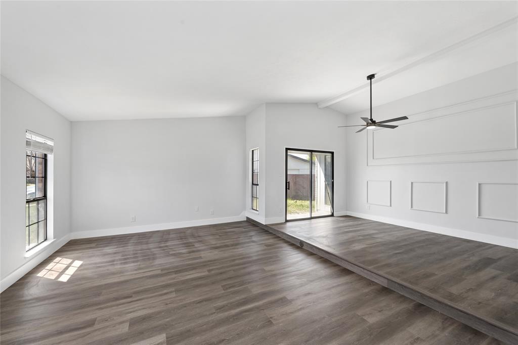 2119 Meadfoot Road Carrollton, TX 75007 - Photo 4 of 34 Unfurnished living room featuring vaulted ceiling, dark wood-style flooring, and a ceiling fan