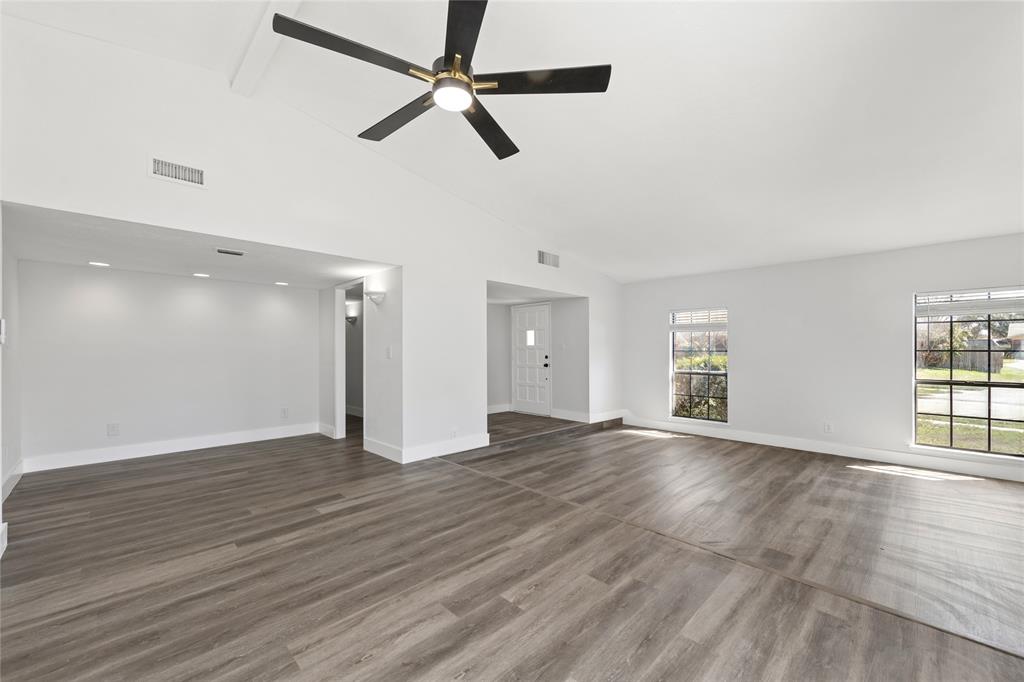 2119 Meadfoot Road Carrollton, TX 75007 - Photo 6 of 34 Unfurnished living room with ceiling fan, vaulted ceiling, and dark wood-type flooring