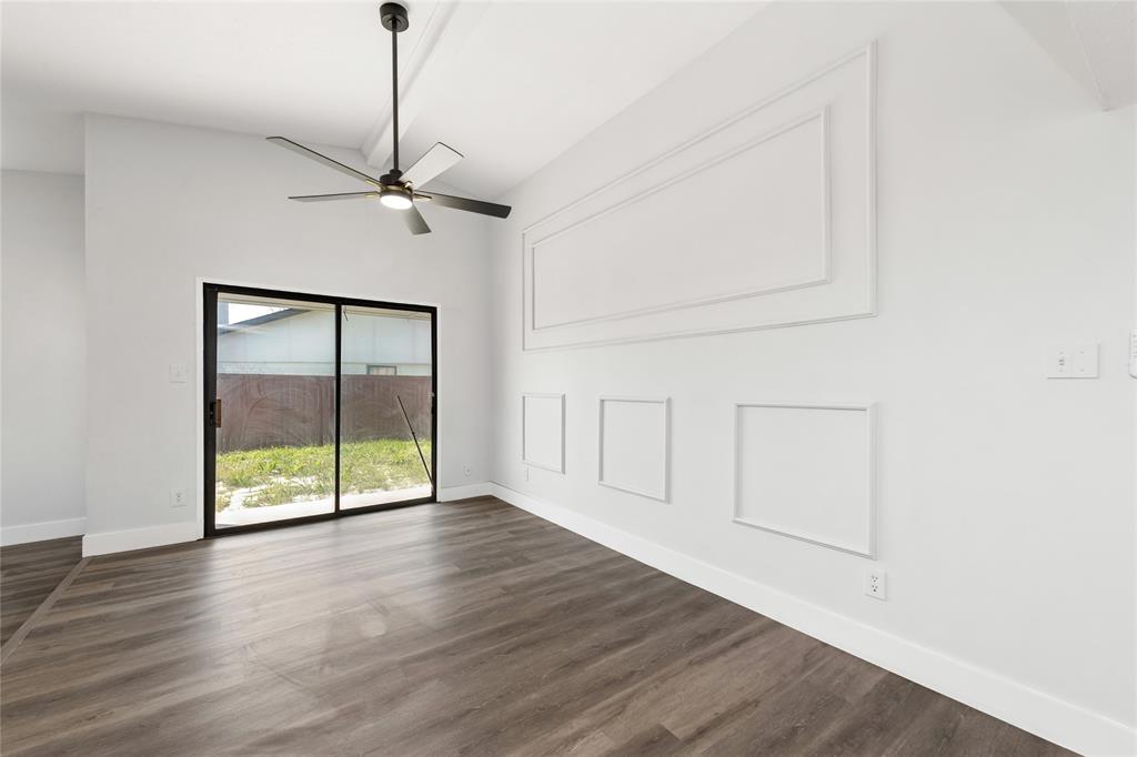 2119 Meadfoot Road Carrollton, TX 75007 - Photo 9 of 34 Empty room with ceiling fan, dark wood-type flooring, and a high ceiling