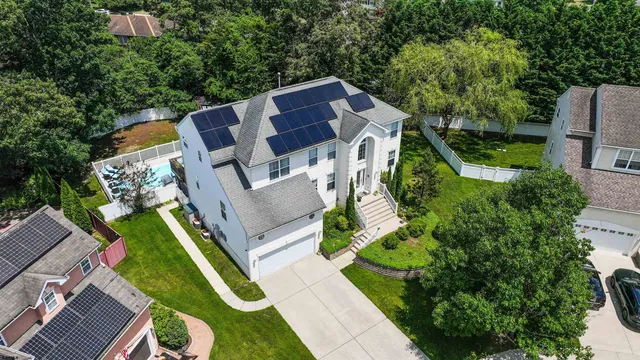 an aerial view of a house with a big yard and large trees