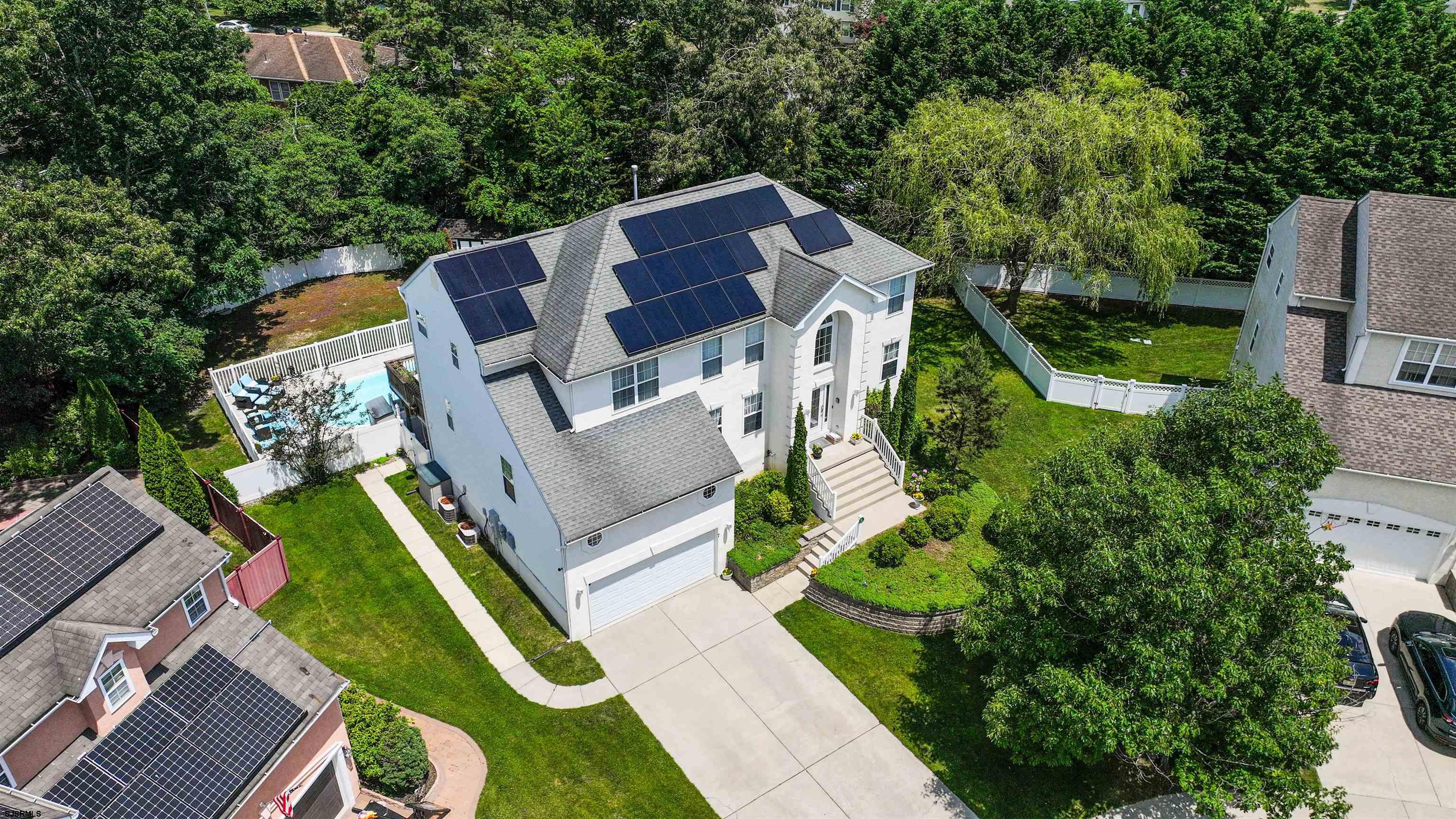 an aerial view of a house with a big yard and large trees
