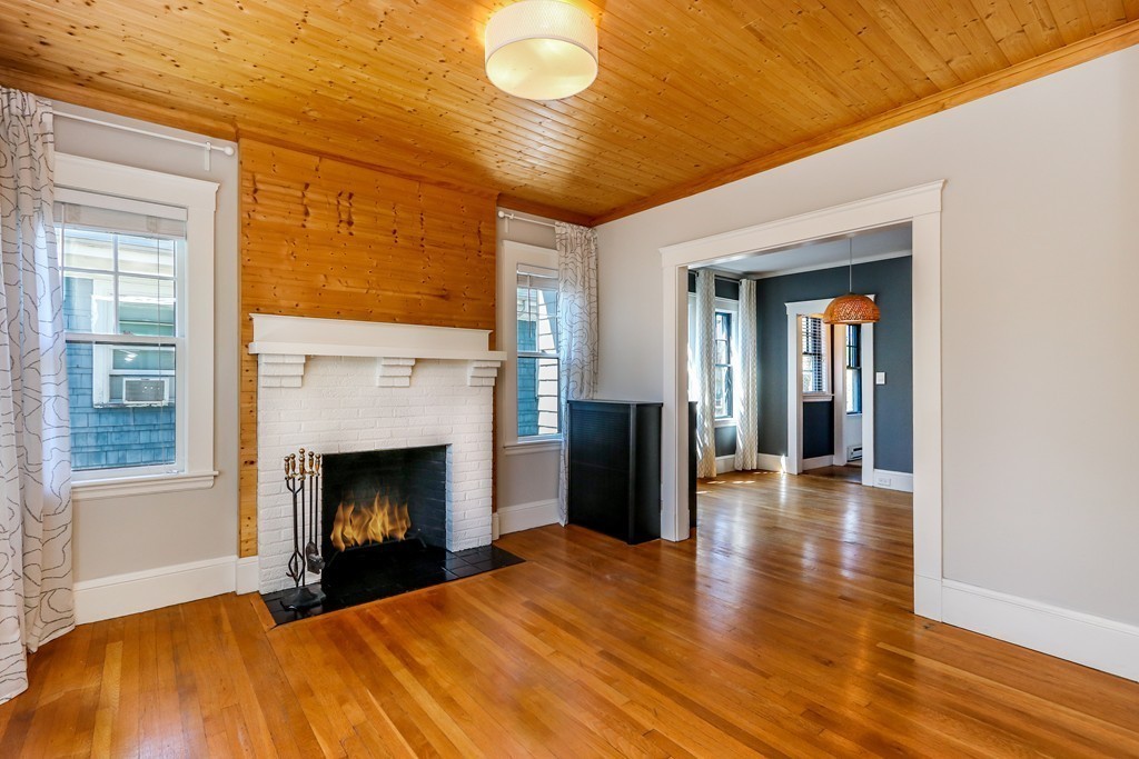 109 Adena Road, Unit 109 Newton, MA 02465 - Photo 4 of 23 a view of an empty room with wooden floor fireplace and a window